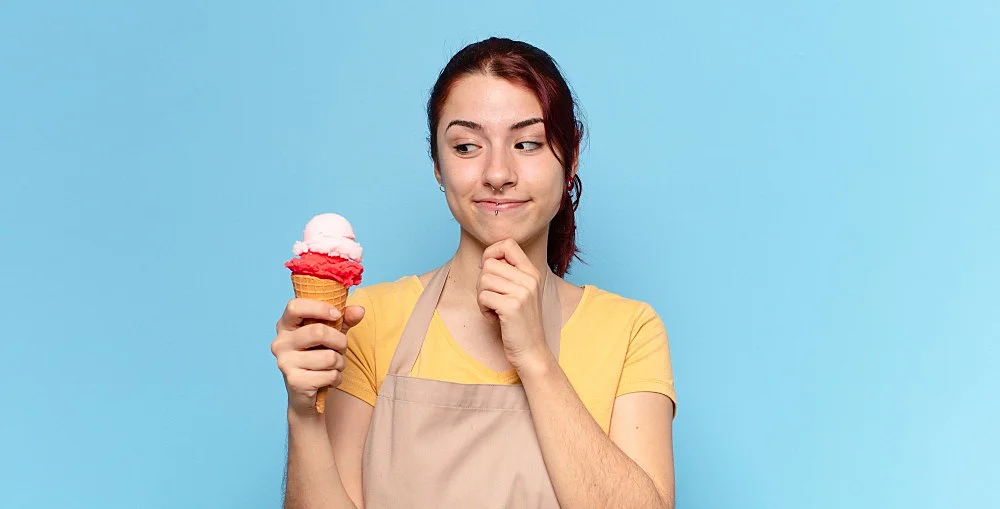 une femme entrain de manger un glace citron et fraise